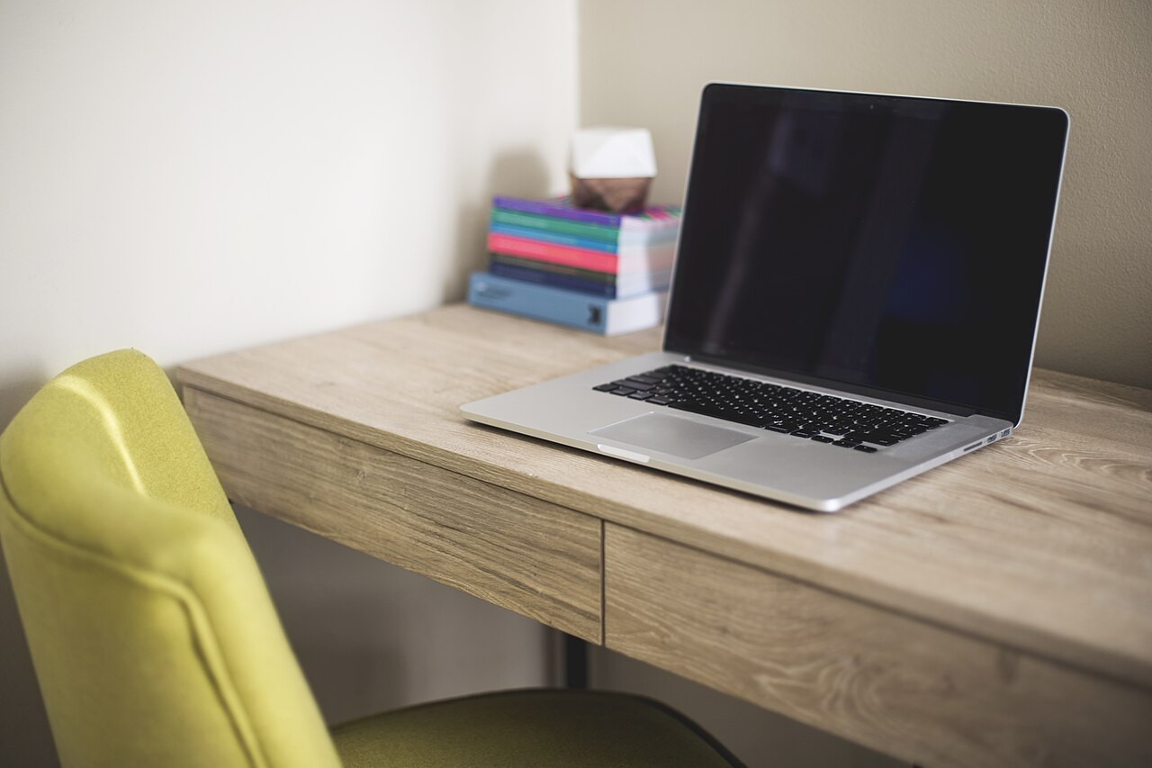 Laptop und Bücher auf einem Schreibtisch